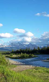 A river winding through a mountain prairie in the sun